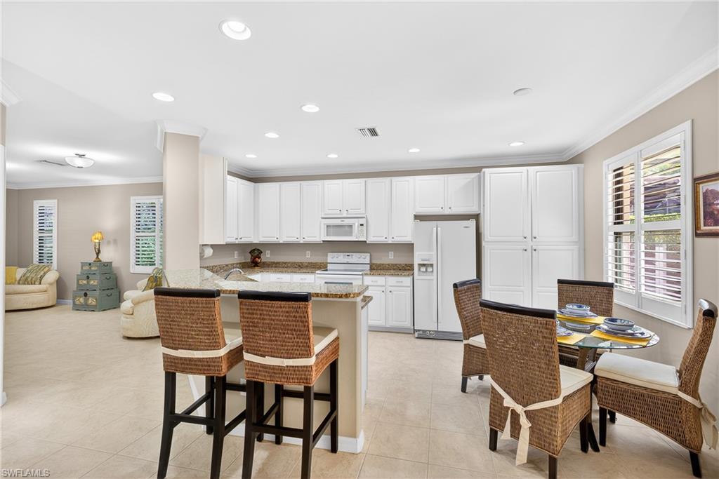 1248 Manado Drive Naples, FL 34113 - Photo 12 of 45 a large kitchen with a table and chairs