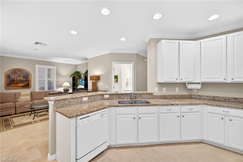 1248 Manado Drive Naples, FL 34113 - Photo 44 of 45 a kitchen with granite countertop a sink and white cabinets