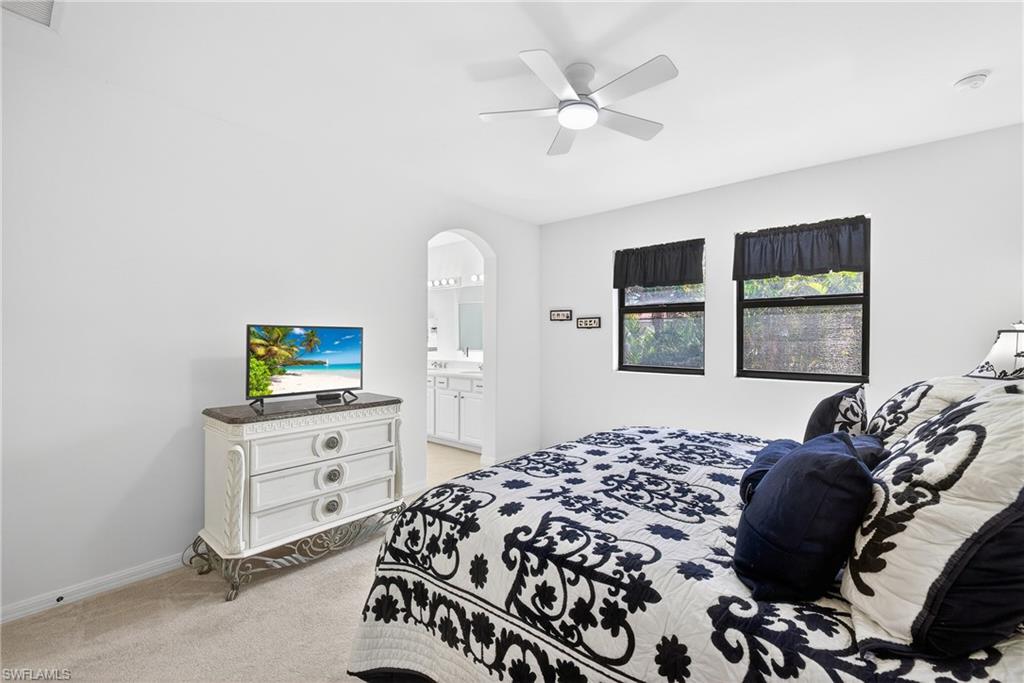 1248 Manado Drive Naples, FL 34113 - Photo 17 of 45 a bedroom with a bed and a flat tv screen on dresser