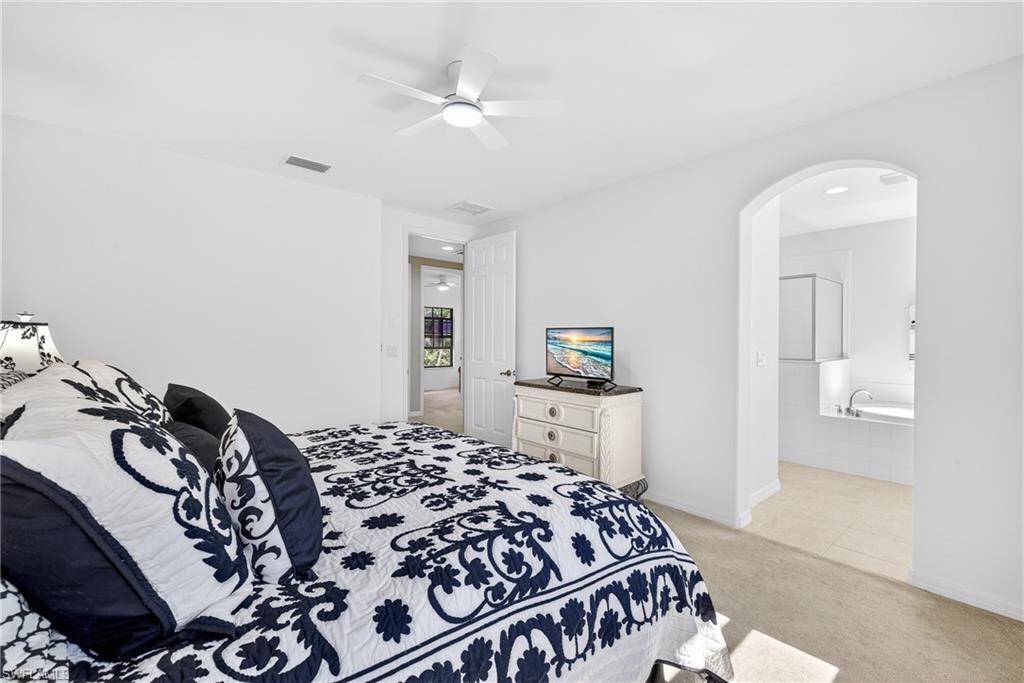 1248 Manado Drive Naples, FL 34113 - Photo 18 of 45 a bedroom with a bed and a television