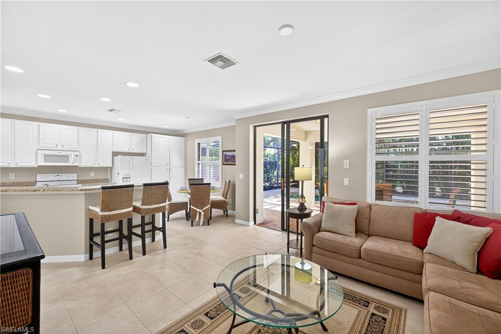 1248 Manado Drive Naples, FL 34113 - Photo 9 of 45 a living room with furniture and a dining table with kitchen view