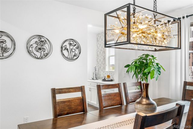 a vase of flowers sitting on a table with a potted plant