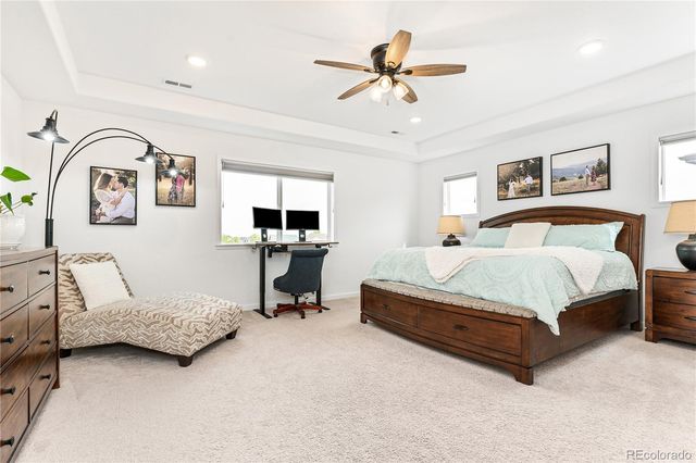 a spacious bedroom with a bed a couch and a chandelier