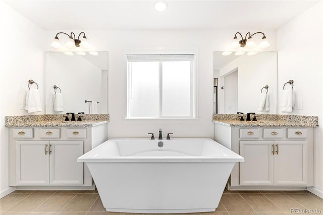 a bathroom with a double vanity sink a mirror and a bathtub