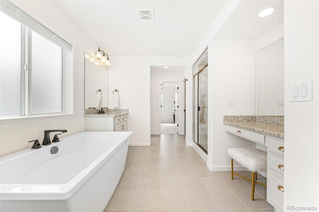 a bathroom with a tub sink and mirror