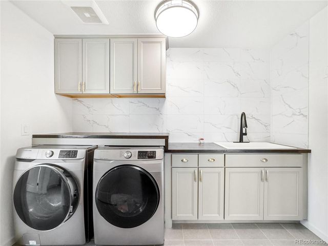 a utility room with sink dryer and washer