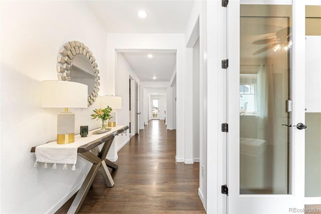 a view of a hallway with furniture and wooden floor