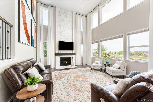 a living room with furniture a fireplace and a floor to ceiling window