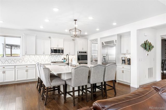 a large kitchen with cabinets table and chairs