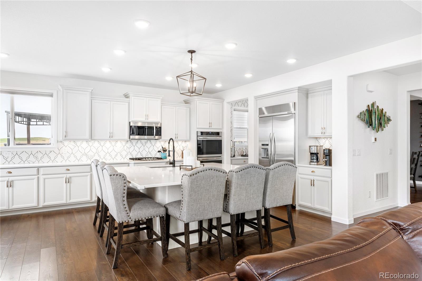 16391 Buffalo Run Drive Commerce City, CO 80022 - Photo 10 of 49 a large kitchen with cabinets table and chairs