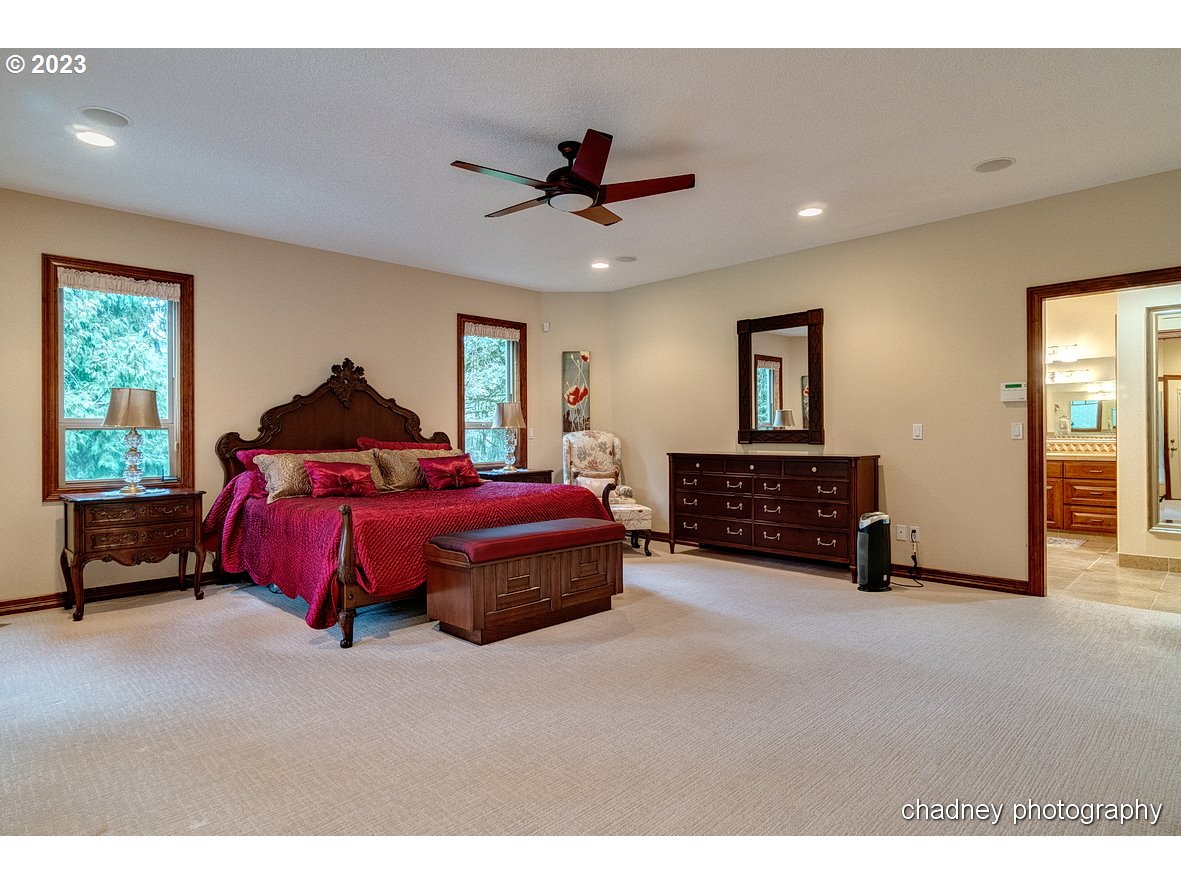 13507 Southeast Richey Road Boring, OR 97009 - Photo 13 of 34 a spacious bedroom with a bed a dresser and a chandelier