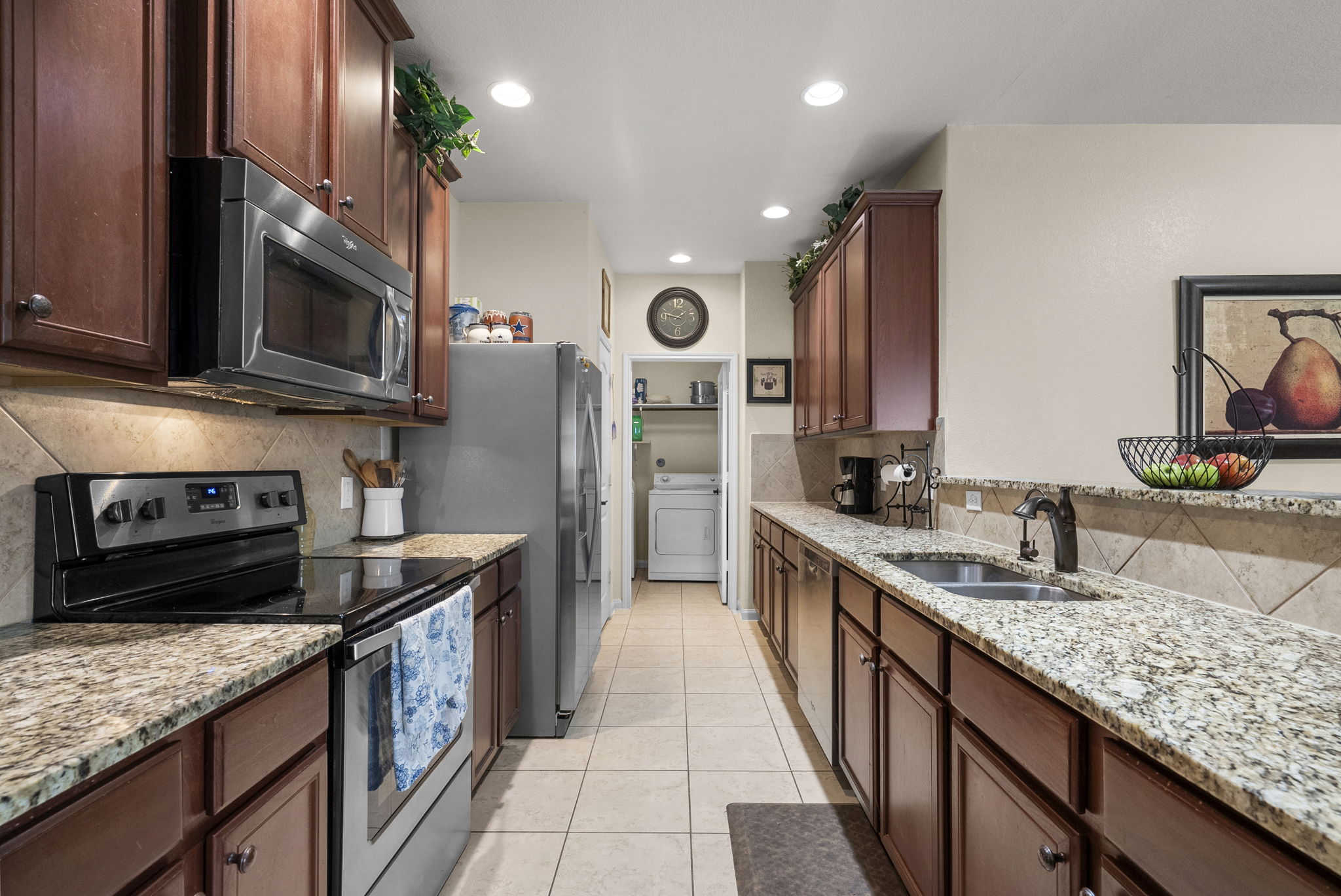 1617 Treeta Trail Kyle, TX 78640 - Photo 2 of 39 Kitchen featuring stainless steel appliances, light stone counters, light tile patterned floors, washer / clothes dryer, and recessed lighting