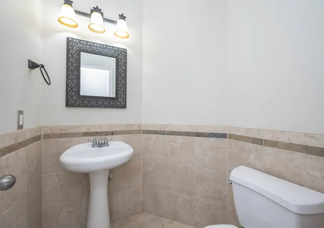 a bathroom with a toilet sink and mirror