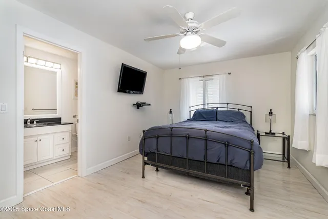 a spacious bedroom with a bed and a flat screen tv