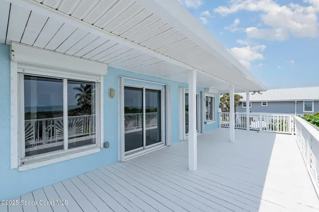 a view of a porch with wooden floor and windows