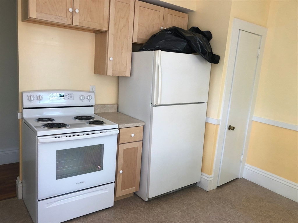 52 Pleasant Street, Unit 2 Lexington, MA 02421 - Photo 13 of 13 a white refrigerator freezer and a stove sitting inside of a kitchen