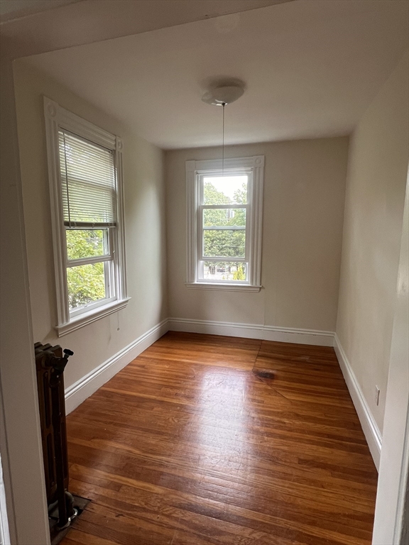52 Pleasant Street, Unit 2 Lexington, MA 02421 - Photo 3 of 13 a view of an empty room with wooden floor and a window