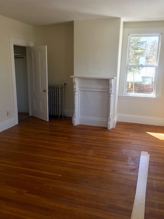 52 Pleasant Street, Unit 2 Lexington, MA 02421 - Photo 9 of 13 an empty room with wooden floor and windows