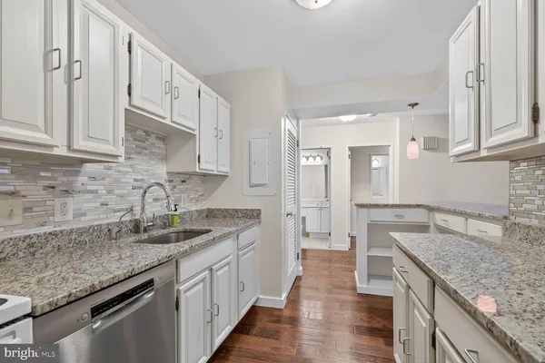 a kitchen with granite countertop a sink stove and cabinets