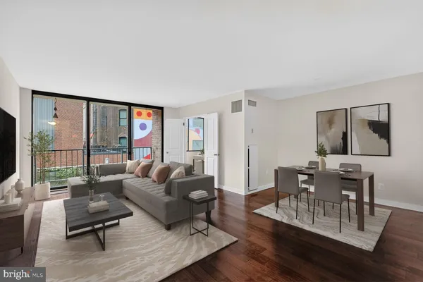 a living room with furniture and a wooden floor