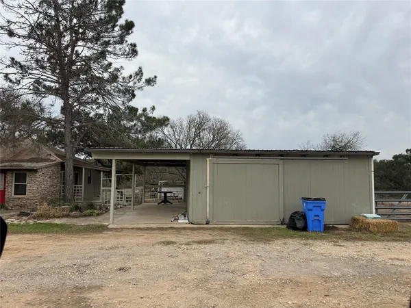 a view of the house with backyard and a trees