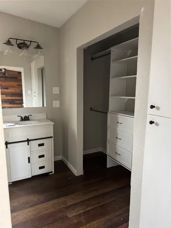 a view of walk in closet with cabinet and wooden floor