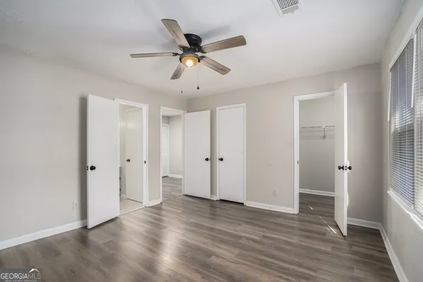 a view of a livingroom with a ceiling fan and wooden floor
