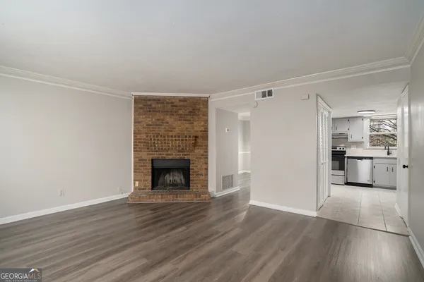 a view of a livingroom with wooden floor a fireplace and window
