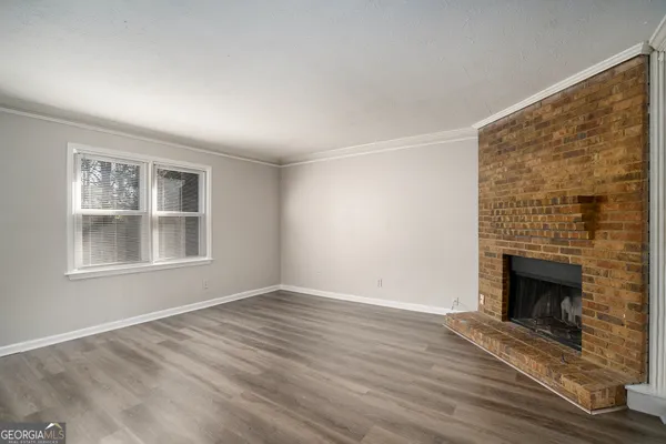 a view of empty room with wooden floor and fireplace