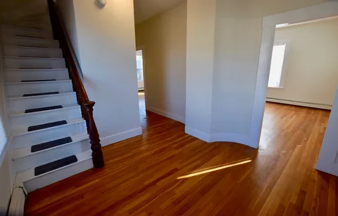 a view of a room with wooden floor and stairs