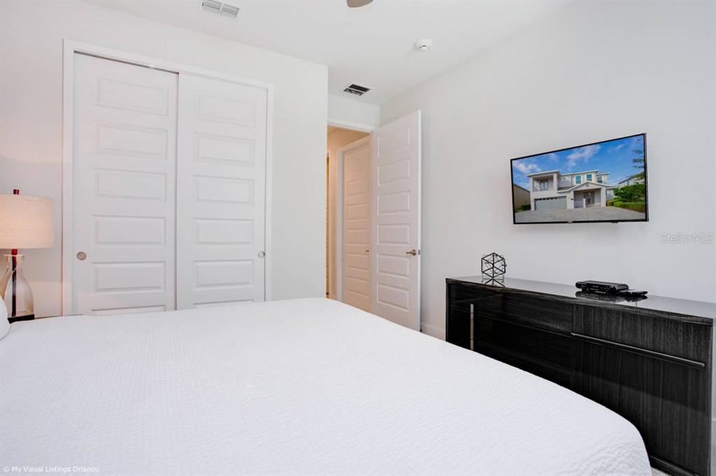 7736 Graben Street Kissimmee, FL 34747 - Photo 12 of 62 a bedroom with a bed and a cabinet