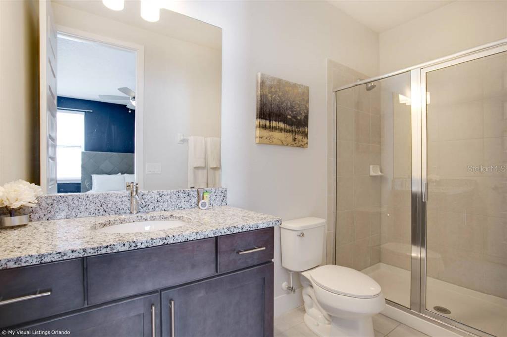 7736 Graben Street Kissimmee, FL 34747 - Photo 16 of 62 a bathroom with a granite countertop sink toilet and shower