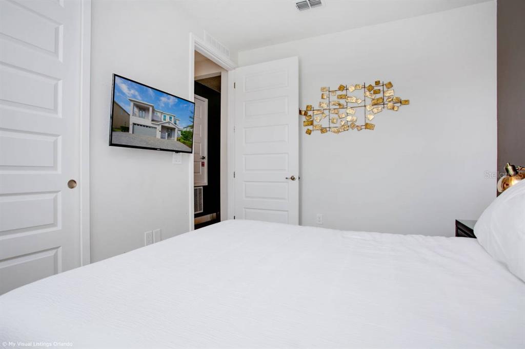 7736 Graben Street Kissimmee, FL 34747 - Photo 18 of 62 a bedroom with a bed and a refrigerator