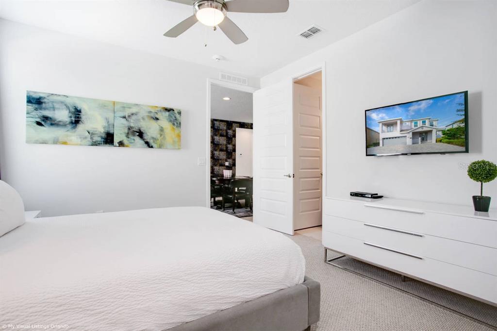 7736 Graben Street Kissimmee, FL 34747 - Photo 19 of 62 a bedroom with a bed and a flat screen tv