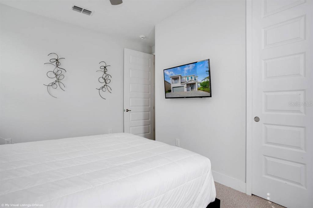 7736 Graben Street Kissimmee, FL 34747 - Photo 22 of 62 a bedroom with a bed and a painting on the wall