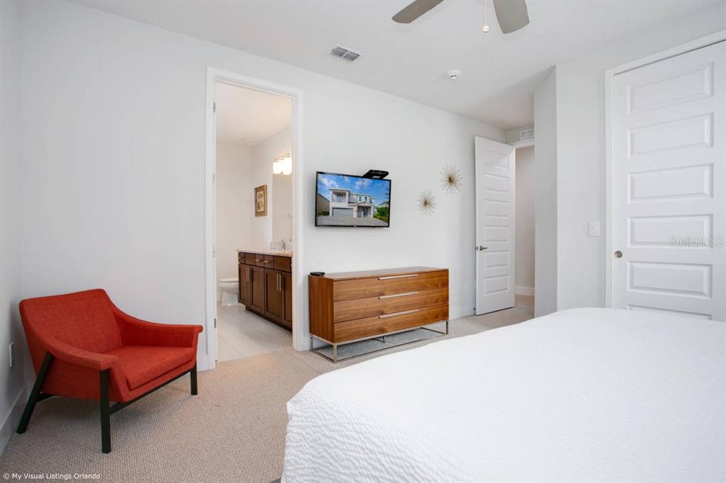 7736 Graben Street Kissimmee, FL 34747 - Photo 24 of 62 a bedroom with a bed and a chair