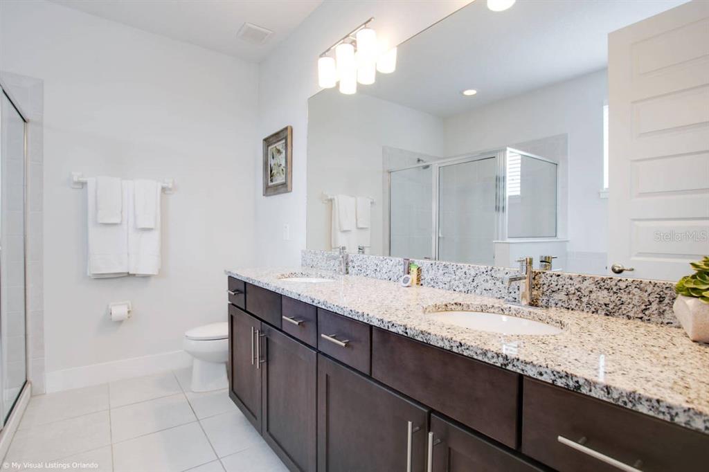 7736 Graben Street Kissimmee, FL 34747 - Photo 26 of 62 a bathroom with a sink double vanity granite and a toilet