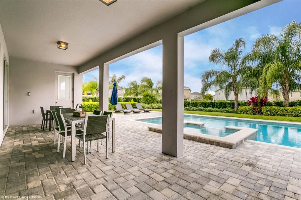 7736 Graben Street Kissimmee, FL 34747 - Photo 31 of 62 a view of a patio with a table chairs and a swimming pool