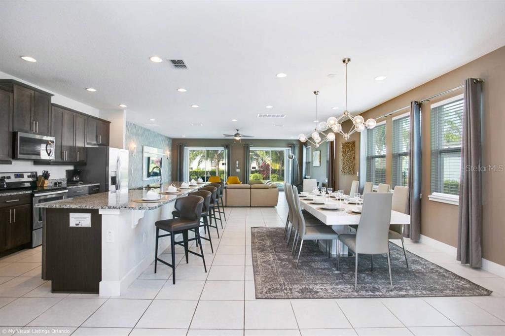 7736 Graben Street Kissimmee, FL 34747 - Photo 46 of 62 a kitchen with stainless steel appliances granite countertop a table and chairs