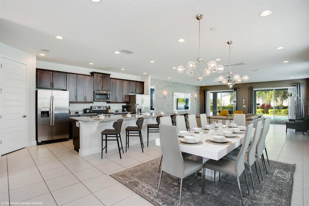 7736 Graben Street Kissimmee, FL 34747 - Photo 47 of 62 a view of a dining room and livingroom with furniture a rug a kitchen island a chandelier and kitchen view
