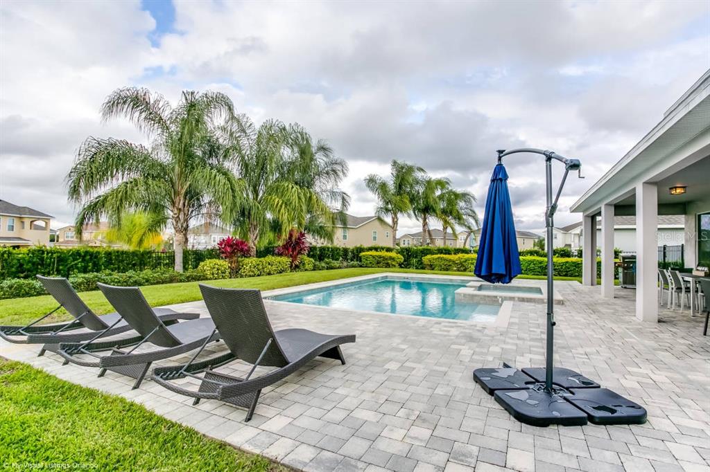 7736 Graben Street Kissimmee, FL 34747 - Photo 5 of 62 a view of a chairs and table in patio with a swimming pool