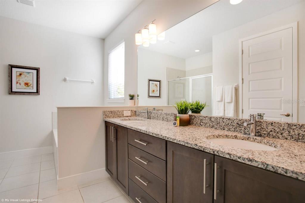 7736 Graben Street Kissimmee, FL 34747 - Photo 10 of 62 a bathroom with a granite countertop sink and a mirror
