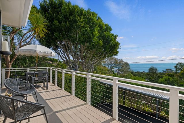 a view of a dining table and chairs in the balcony