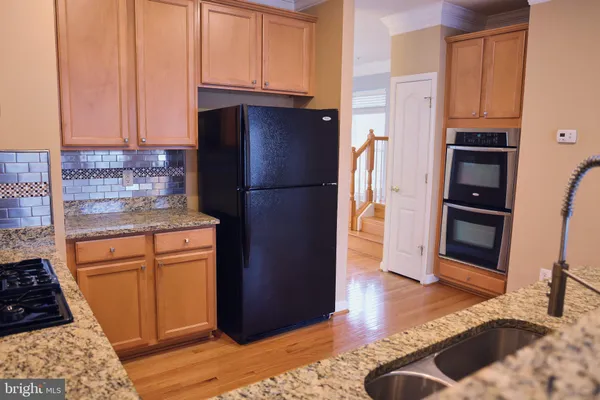 a kitchen with stainless steel appliances granite countertop a refrigerator stove and cabinets