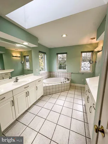 a spacious bathroom with a double vanity sink a mirror and a bathtub