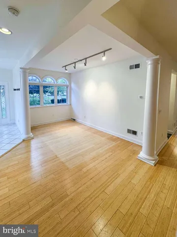 a view of a big room with wooden floor and windows