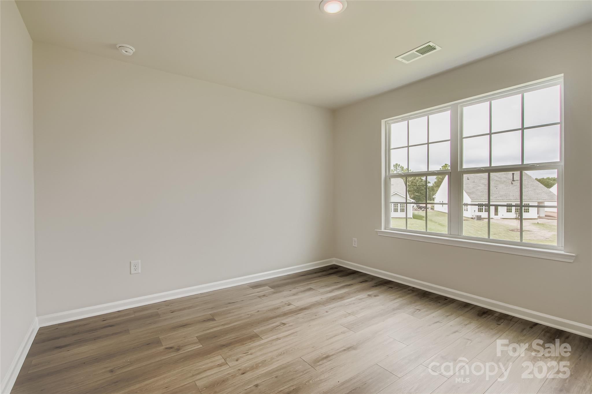 2803 Morning Song Way Lancaster, SC 29720 - Photo 12 of 18 an empty room with wooden floor and windows