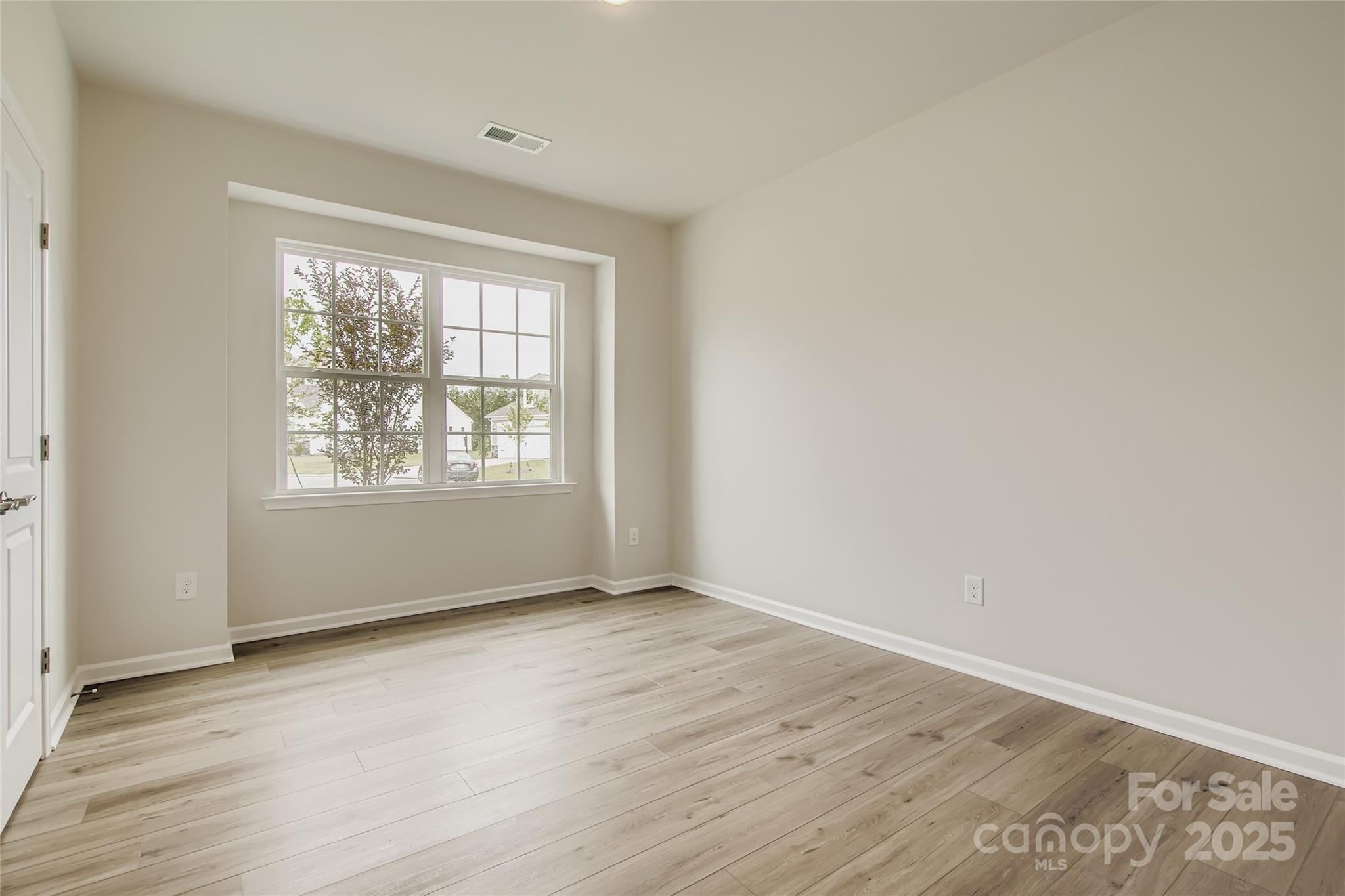 2803 Morning Song Way Lancaster, SC 29720 - Photo 10 of 18 an empty room with wooden floor and windows