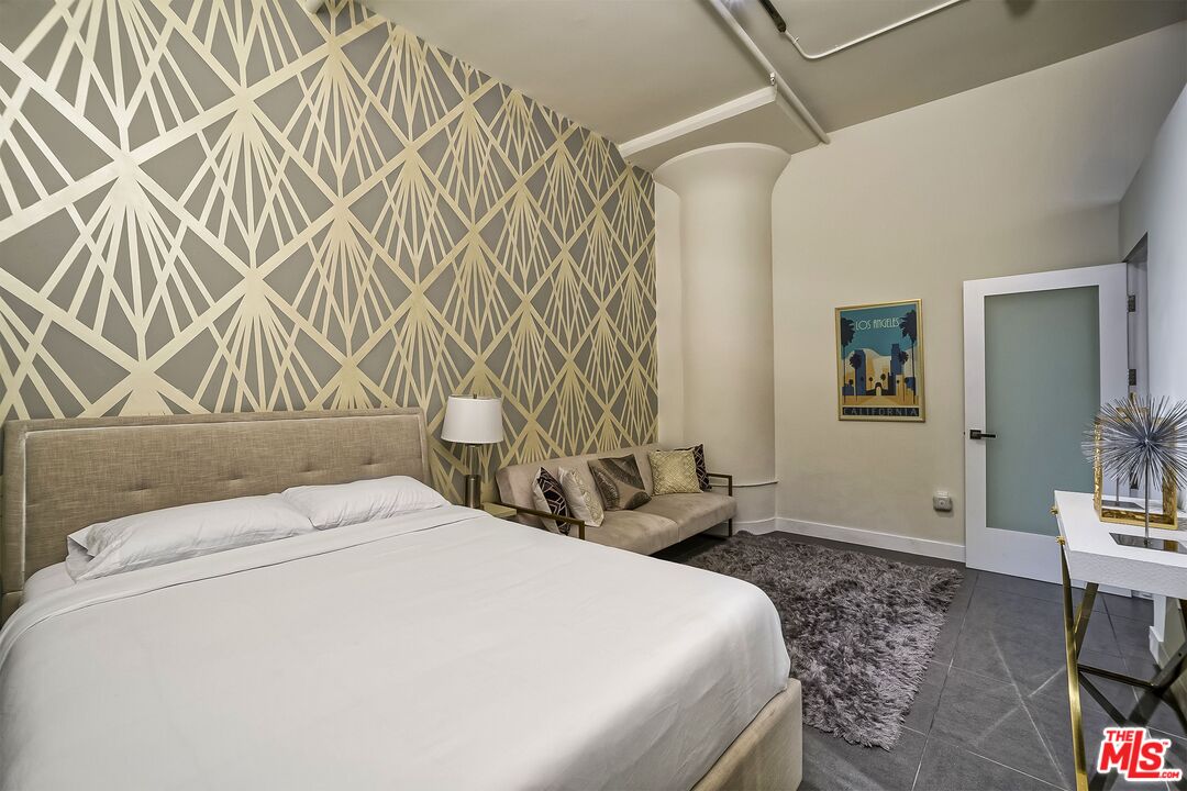 939 South Broadway, Unit 304 Los Angeles, CA 90015 - Photo 16 of 21 a bedroom with a bed and a lamp on the dresser