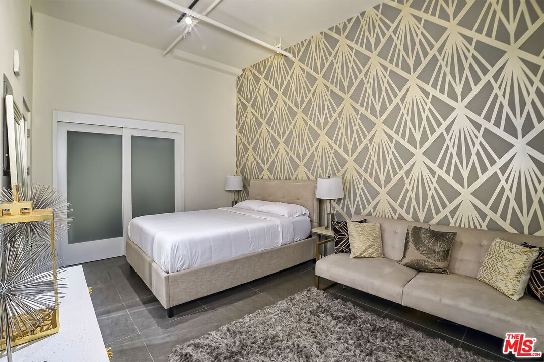 939 South Broadway, Unit 304 Los Angeles, CA 90015 - Photo 19 of 21 a bedroom with a bed and a couch